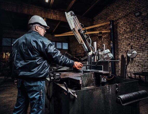 Experienced worker is working at metal factory using special machine tool KENITRA I2MK.