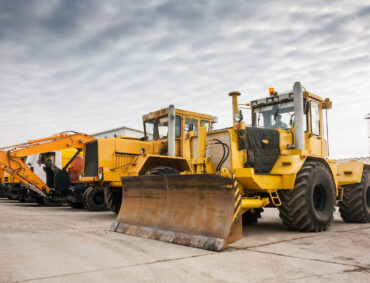 Two heavy wheeled tractor one excavator and other construction machinery