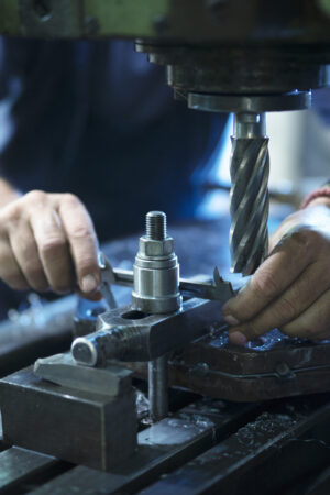 Worker operating industrial machine in metal workshop. Worker operating industrial machine in metal workshop.
